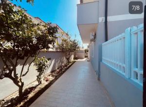 a walkway leading to a building with a blue fence at Sweet Stay in Fiumicino