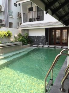 a swimming pool in front of a building at Valentier Cafe and Hotel in Chiang Mai
