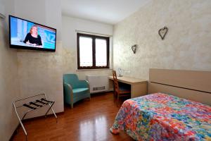 a bedroom with a bed and a tv on the wall at Hotel Italia in Monfalcone