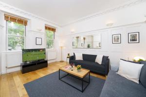 a living room with a couch and a tv at 2 Bedr, 3 Beds, 1 Bath Thames, Trafalgar SQ in London