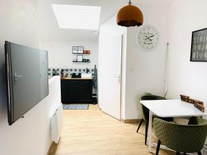 a kitchen with a table and a clock on the wall at Le Studio d'Emy in Tiffauges