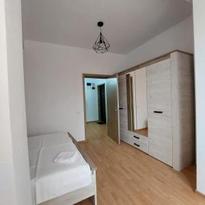 een witte slaapkamer met een bed en een spiegel bij Apartament1 in Constanţa