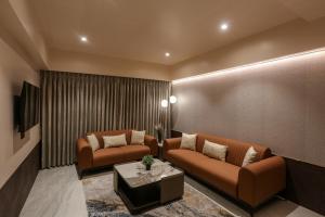a living room with two couches and a table at Hotel Corporate in Navi Mumbai +27 photos
