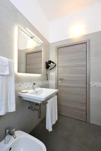 a bathroom with a sink and a toilet and a mirror at Hotel Italia in Monfalcone