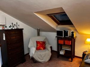 um quarto no sótão com uma cadeira com uma almofada em Zanna Casa Vacanza em Grottammare