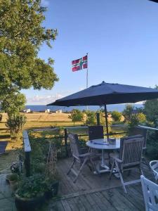 a table and chairs with an umbrella on a deck at Bølshavnvej5 Bed & Breakfast in Svaneke