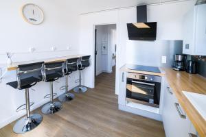 アミアンにあるOasis urbaine - proche centre-ville - garageの白いキャビネットとコンロ付きオーブンを備えたキッチン