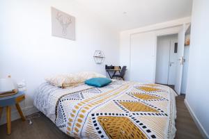 um quarto com uma cama com uma colcha amarela e branca em Oasis urbaine - proche centre-ville - garage em Amiens