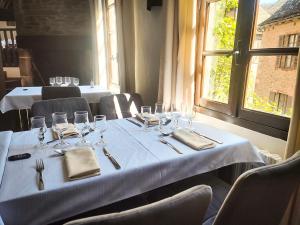 una mesa con copas de vino y servilletas en un restaurante en Auberge Saint Jacques, en Conques