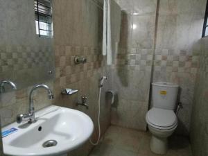 a bathroom with a toilet and a sink at Royal Living Hotel & Suites in Chittagong