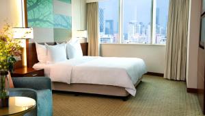 a hotel room with a bed and a large window at Holiday Inn Shenzhen Donghua, an IHG Hotel in Shenzhen