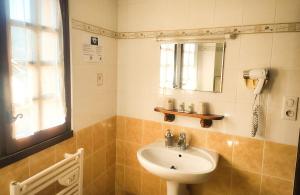 La salle de bains est pourvue d'un lavabo et d'un miroir. dans l'établissement Auberge Saint Jacques, à Conques