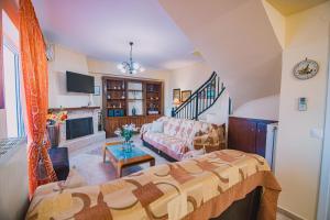 Villa Olga Sea Front Katakolo - Happy Rentals في كاتاكولو: غرفة معيشة مع أريكة ومدفأة