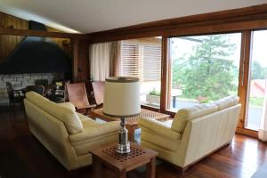sala de estar con 2 sofás y mesa con lámpara en Casa Rural Finca San Lorenzo, en Prado