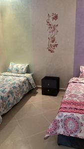 a bedroom with two beds and a stenciled wall at LH résidence Mezouar 1 in Laayoune