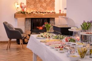 a table with many plates of food and a fireplace at Karkonoskie Widoki in Karpacz