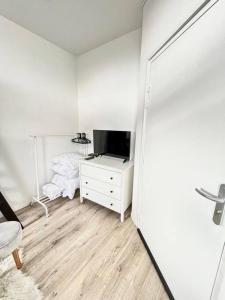 um quarto branco com uma cama e uma televisão em ROME - Studio meublé à Reims em Reims