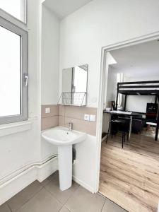 uma casa de banho branca com um lavatório e um piano em ROME - Studio meublé à Reims em Reims