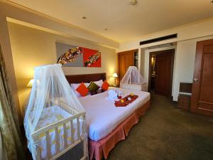 Habitación de hotel con cama y cuna en Songphanburi Hotel, en Suphanburi