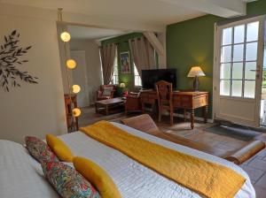 a bedroom with a large bed and a living room at Le Relais Des Dalles in Sassetot-le-Mauconduit