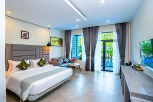 a bedroom with a large bed and a living room at Rainforest Hotel by NSUN in Kampot