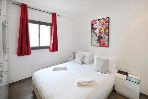 - une chambre avec un lit blanc et des rideaux rouges dans l'établissement Fuzzy Peach by HolyGuest, à Tel Aviv