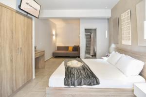 a bedroom with a white bed and a living room at Medusa studios in Sarti