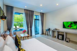 salon z łóżkiem i telewizorem w obiekcie Rainforest Hotel by NSUN w mieście Kâmpôt