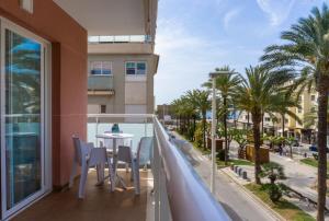 a balcony with a table and chairs and palm trees at Apartamento mediterráneo en pleno corazón de Moraira in Moraira