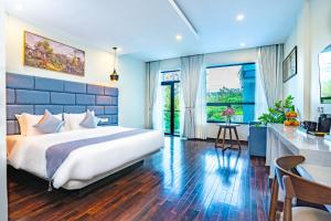 a bedroom with a large bed and a kitchen at Rainforest Hotel by NSUN in Kampot