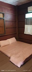 a bed in a room with a wooden wall at Chanmuang guesthouse in Mae Hong Son