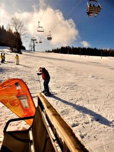 um homem em esquis na neve ao lado de um teleférico em ROUBENKA-JESENKA II em Dolní Moravice