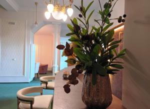 eine Vase mit Blumen auf einem Tisch in einem Zimmer in der Unterkunft Hotel Maxim in Marienbad