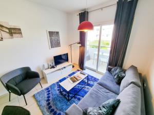 a living room with a couch and a tv at Seaside Heaven Apartment With Pool in Larnaca