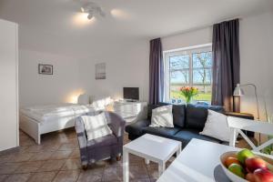 ein Hotelzimmer mit einem Bett und einem Wohnzimmer in der Unterkunft Deichhus Nordseeliebe direkt am Deich - Nordsee - Dagebüll - Am Vogelreservat in Dagebüll