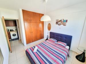 a bedroom with a bed with a striped blanket at Seaside Heaven Apartment With Pool in Larnaca