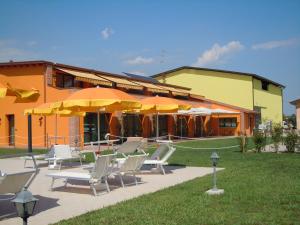 a patio with chairs and umbrellas in front of a building at Agriturismo Aver in Villafranca di Verona