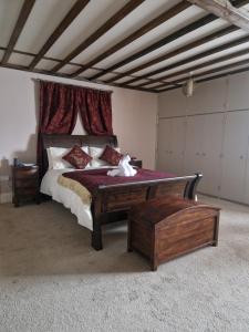 a bedroom with a large bed and a wooden table at Primroses, Wood Farm in Shipdham