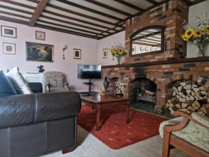 sala de estar con sofá y chimenea en Primroses, Wood Farm, en Shipdham