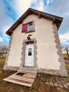 uma pequena casa de tijolos com uma porta branca em Gîte Le Passage 133 em Clavières-dʼOutre