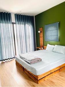 1 dormitorio con 1 cama grande y paredes verdes en Ostrich homestay - Venue Travel, en Ba Vì