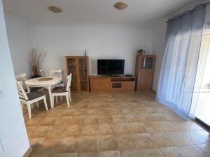 ein Wohnzimmer mit Tisch und Fernseher in der Unterkunft RESIDENCIAL JARDINES DEL TEIDE, 126 in Puerto de la Cruz
