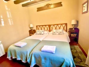1 dormitorio con 2 camas y toallas. en El huerto de Candeleda, en Candeleda