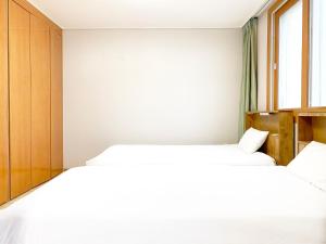 two beds in a bedroom with a window at Jungheung Gold Spa & Resort in Naju