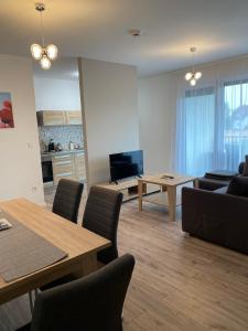 salon ze stołami i krzesłami oraz kuchnia w obiekcie Paskom Apartmanház w mieście Nyergesújfalu