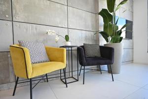 two chairs and a table in a room with a plant at Design 3BR in TLV center by HolyGuest in Tel Aviv