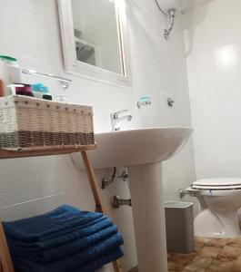 een badkamer met een wastafel, een spiegel en een toilet bij Casa freogan in Castelsardo