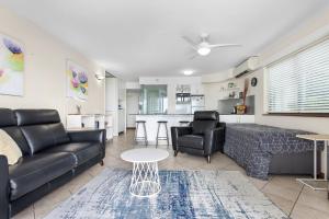 uma sala de estar com um sofá e uma mesa em Cairns Esplanade Apartment em Cairns