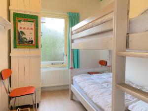 Un dormitorio con literas y una ventana. en Previnaireweg 16, en Callantsoog