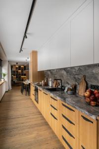 a kitchen with wooden cabinets and a counter top at Edinburgh loft-style apartment in Jūrmala
